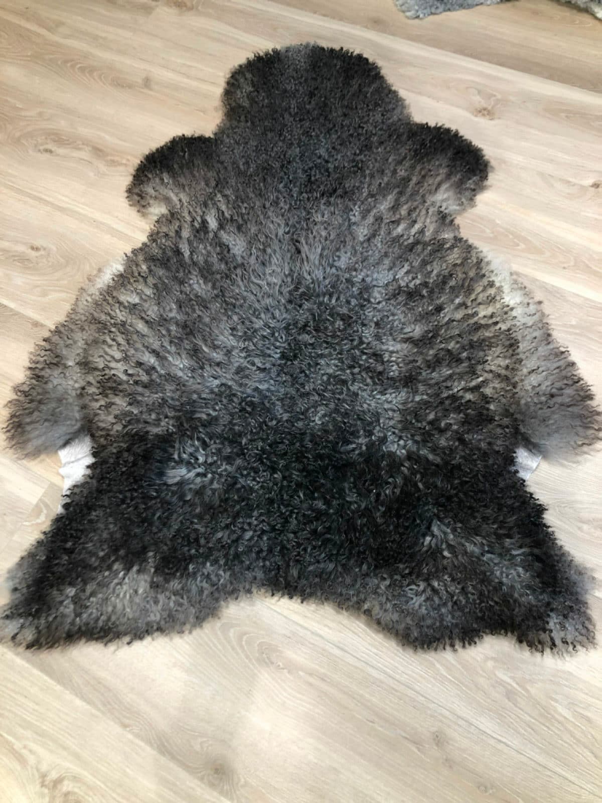 Uklippet lammeskinn, mørkt med grå tupper.